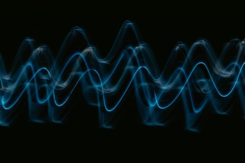Sound wave visualization glowing in dark ambient room