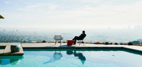 Wealthy man waiting by pool for escort
