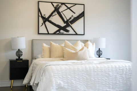 Cozy bedroom with warm lighting creating an intimate incall atmosphere.
