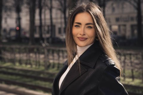 Elegant French escort companion in sophisticated black dress posing gracefully