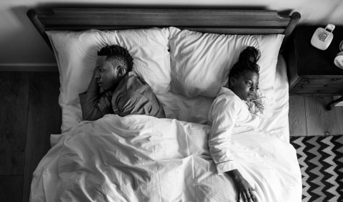 Couple in bed without intimacy.
