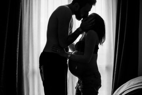 Pregnant escort glowing in soft light