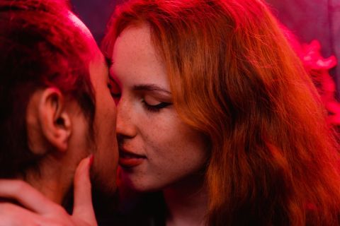 Woman laughing freely in bed feeling sexual freedom