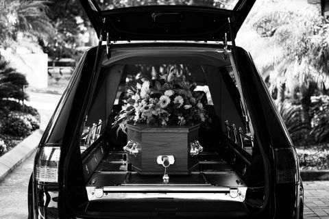 Hearse carrying coffin of deceased spouse