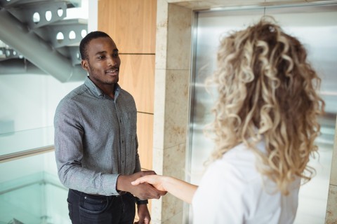 Two colleagues holding hands and connecting romantically