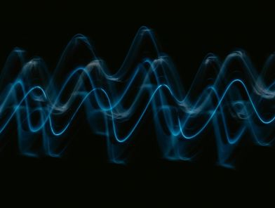 Sound wave visualization glowing in dark ambient room