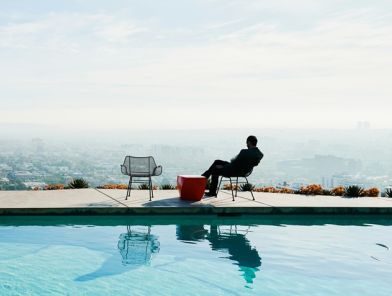 Wealthy man waiting by pool for escort