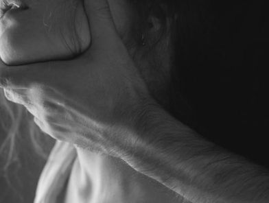Teen covering neck, illustrating sexual choking risks