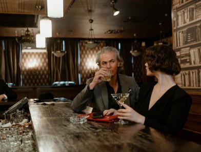 Escort talking with client at bar