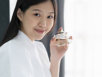 Sexy Asian escort applying perfume