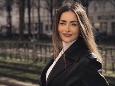 Elegant French escort companion in sophisticated black dress posing gracefully