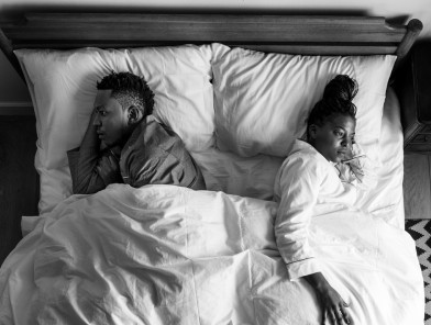 Couple in bed without intimacy.