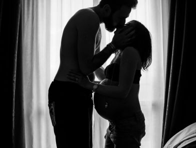 Pregnant escort glowing in soft light