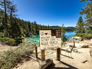 Sunny secluded nudist beach with calm blue water