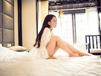 Beginner escort sitting confidently on bed