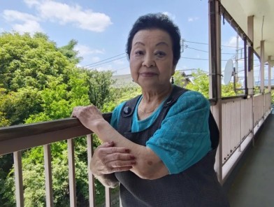 Elderly Japanese woman Yuko Ogasawara smiling confidently.